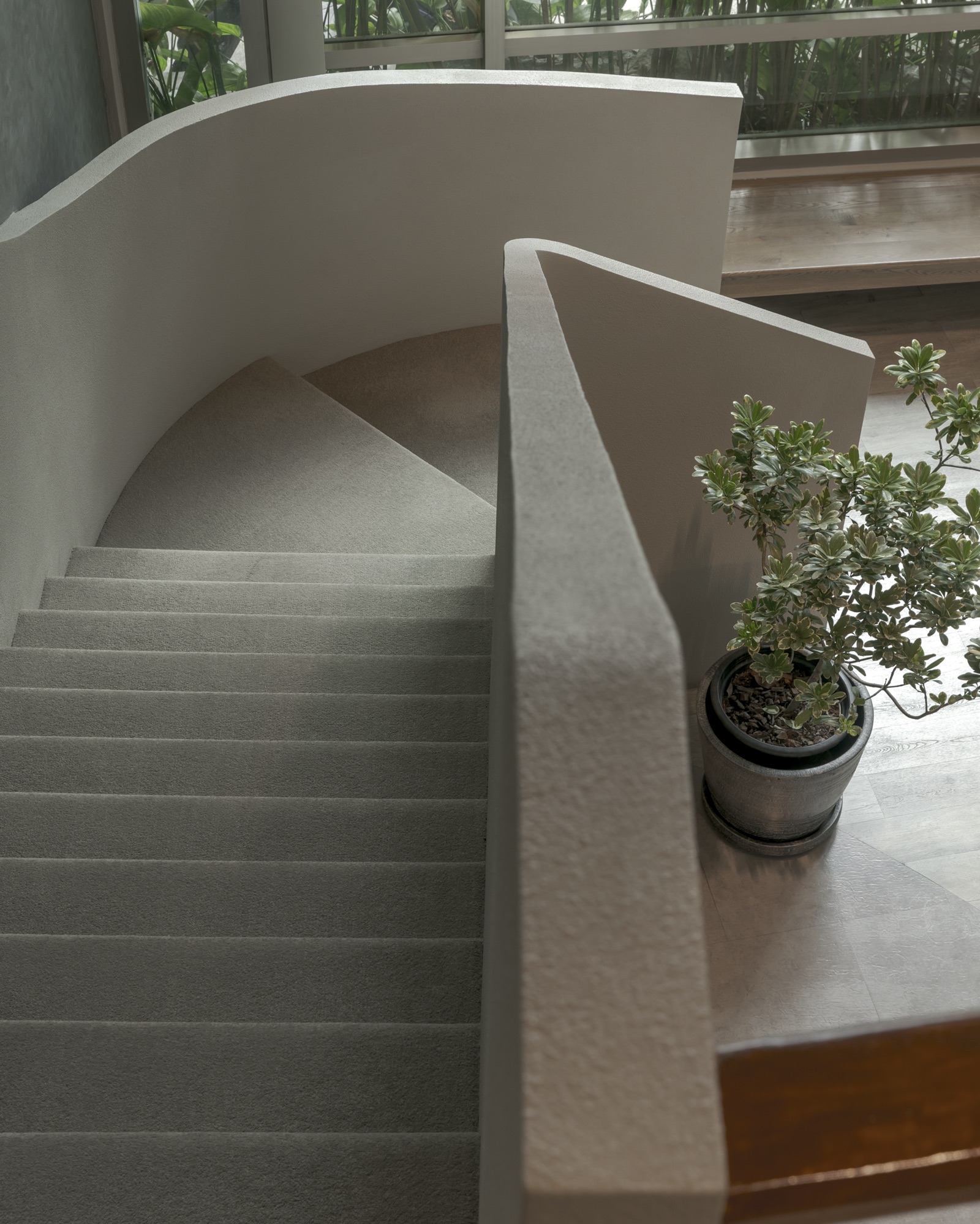 Curved white staircase and indoor planting at Bodytune Wellness Sukhumvit 16