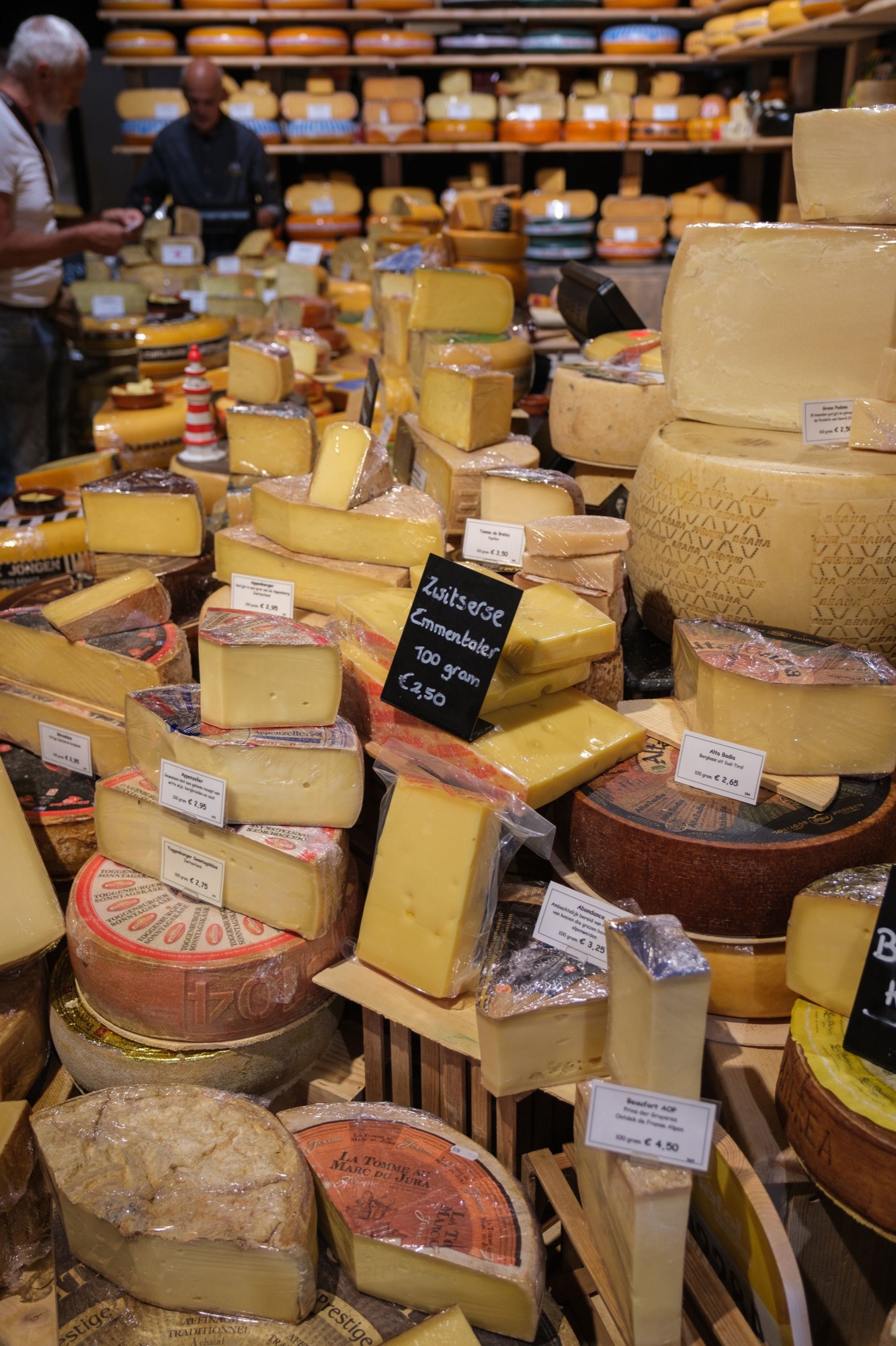 Assorted cheeses arranged across a market counter