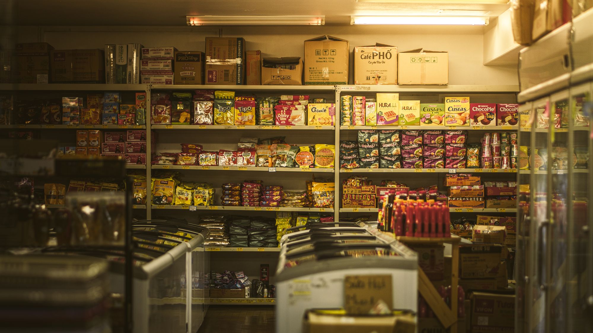 Shelves of packaged food inside a compact Asian grocery store