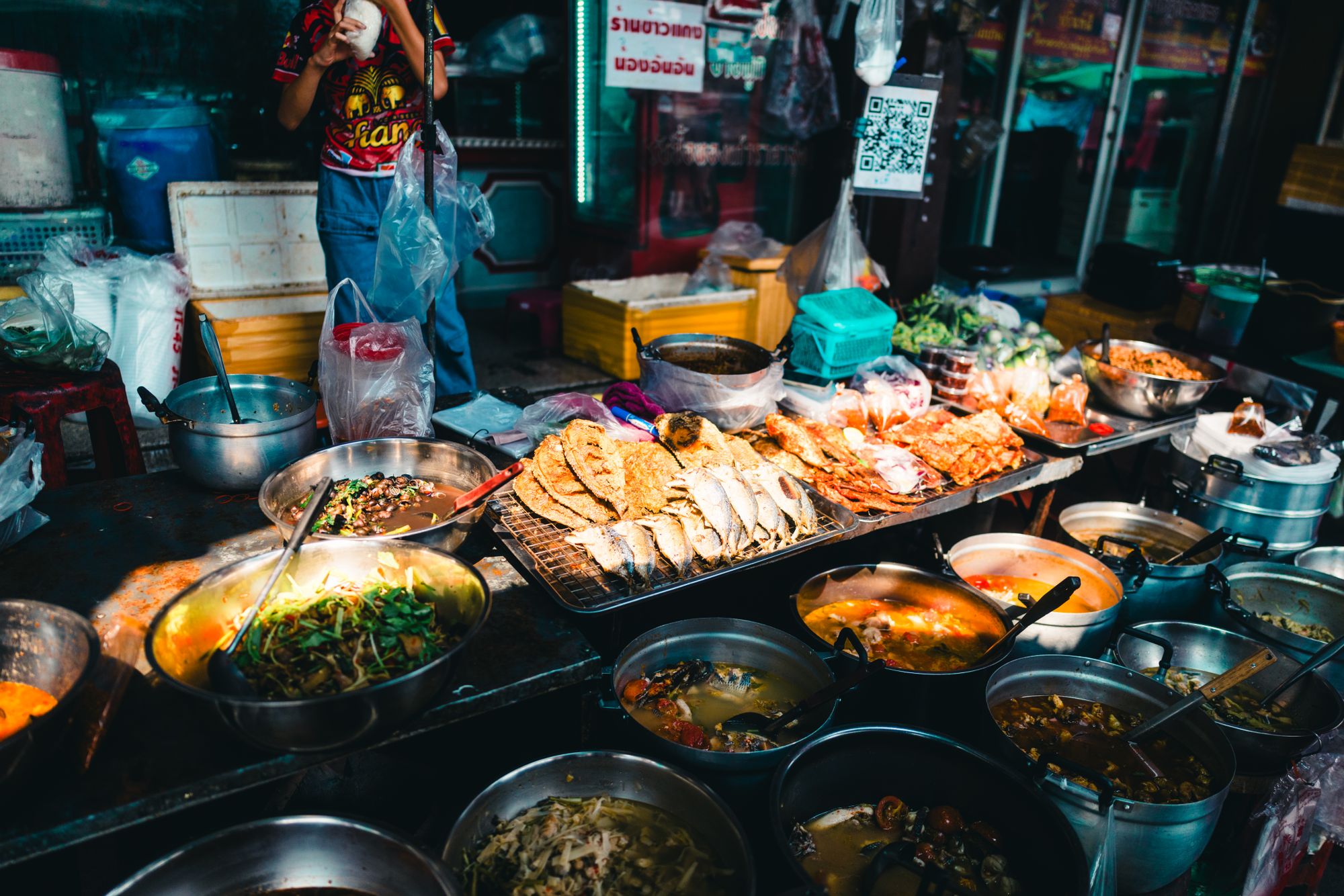 ร้านอาหารริมทางในกรุงเทพฯ จัดวางปลาปรุงสุก แกง และผัก