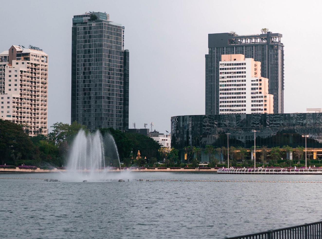 Lake, trees and the Bangkok skyline at Benjakitti Park